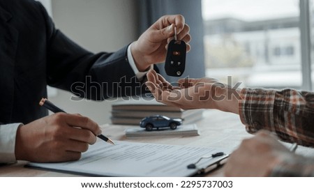 Closeup asian male people car salesman or sales manager offers to sell a car and explains and reads the terms of signing a car contract and insurance.