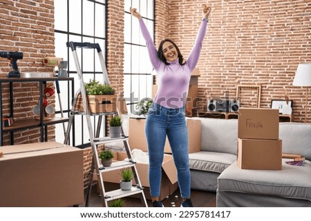 Young hispanic woman smiling confident dancing at new house