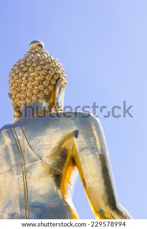 close-up back view big Buddha statue in thailand on blue sky background, copyspace on the right