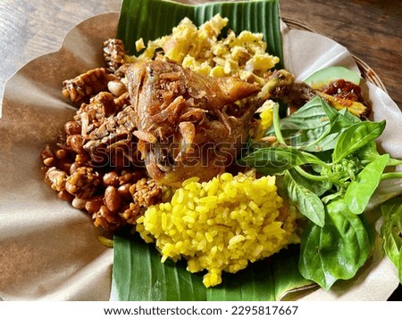 Yellow Rice (Nasi Kuning). This traditional Indonesian dish consists of rice cooked in coconut milk that is usually seasoned with turmeric, lemongrass, and kaffir lime leaves. Royalty-Free Stock Photo #2295817667