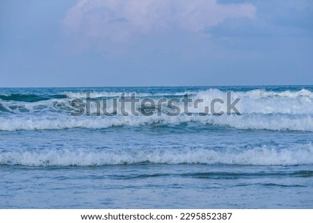 images of blue sky above and blue sea waves at the beach.