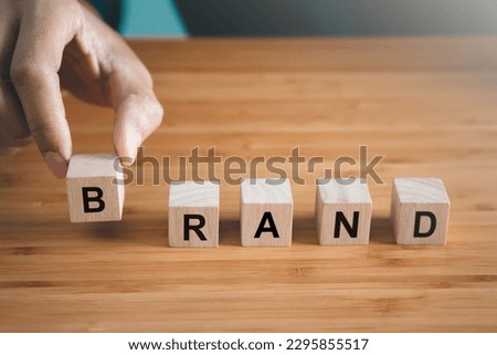 Businessman hold wooden block with brand text. brand building and business concept. Royalty-Free Stock Photo #2295855517