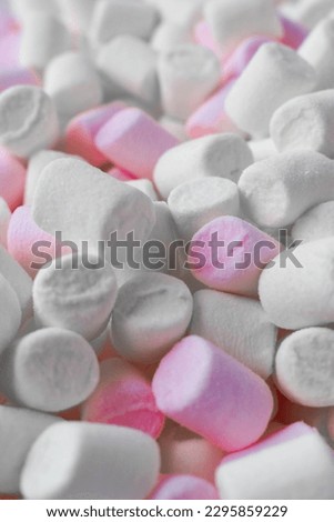 Mini marshmallows in white and light pink. Selective focus. Flat styling.