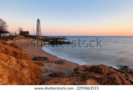 Beautiful sunset of New Haven Light House, Connecticut, USA. The lighthouse is dark, but the tower remains, greeting ships from around the world to New Haven.  Royalty-Free Stock Photo #2295863515