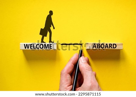 Welcome aboard symbol. Wooden blocks with words 'Welcome aboard'. Businessman hand. Beautiful yellow background, copy space. Business and welcome aboard concept.