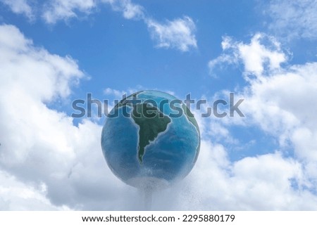 Structure of planet earth with blue sky and clouds in the background.