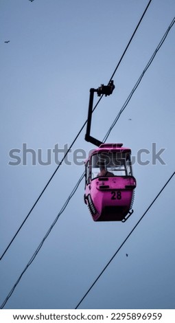 cable car ride at Taman Mini Indonesia Indah, pink with number 28, isolated picture, gray sky as background