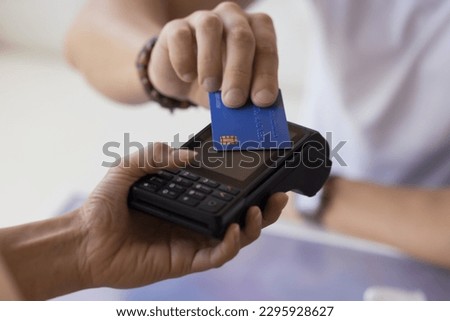 Close up Unrecognizable male customer pay by contactless credit card with NFC tech. Waitress hand hold card reader machine serving to public place client, sell commercial services. Electronic money Royalty-Free Stock Photo #2295928627