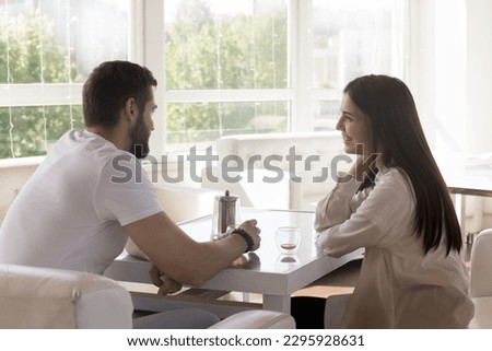 Beautiful millennial 25s couple talking during teatime in cafe, drinking tea, smile, enjoy beverage and pleasant conversation spend romantic dating in cozy restaurant. Romance, relationships, affairs Royalty-Free Stock Photo #2295928631