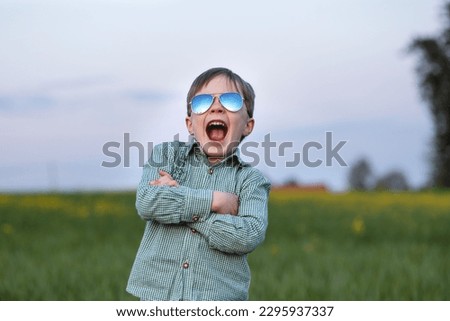a child in sunglasses is pretending to be a cool man Royalty-Free Stock Photo #2295937337