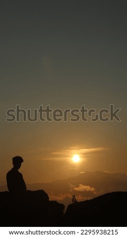 silhouette of a man against a sunrise background