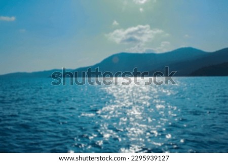 Blurred photo of seascape with hills in the background