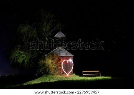 chapel next to a tree, night, starry sky, long exposure, a heart painted with light