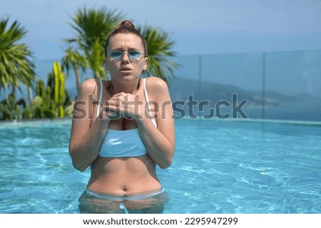 young woman in cold pool, wrinkled from the cold water at the summer in a hotel near sea