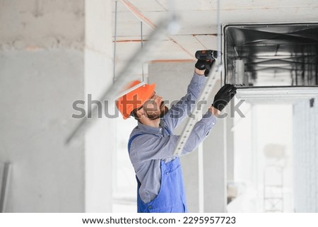 hvac engineer install heat recovery ventilation system for new house. copy space. Royalty-Free Stock Photo #2295957723