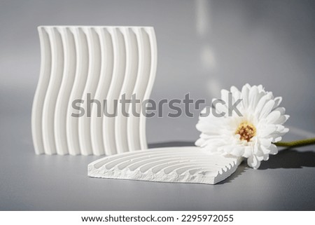 Cosmetic background for product presentation. White empty plaster podium with shadows on gray background