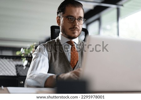 Modern Office Businessman Working on Computer. Portrait of Successful Middle-aged IT Software Engineer Working on a Laptop at his Desk