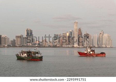 A photo of the waterfront of the city of Panama City and two fishing boats in the ocean 