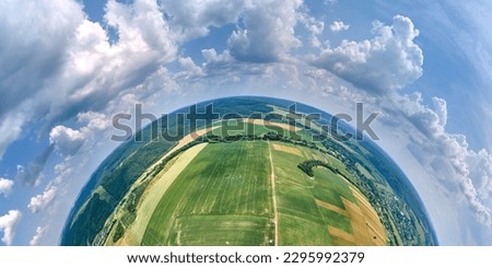 Aerial view from high altitude of little planet earth with green and yellow cultivated agricultural fields with growing crops on bright summer day Royalty-Free Stock Photo #2295992379