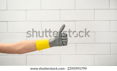 Hand in protective glove showing ok sign