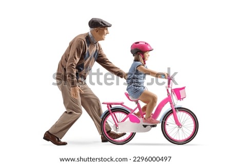 Grandfather teaching a little girl how to ride a bicycle isolated on white background