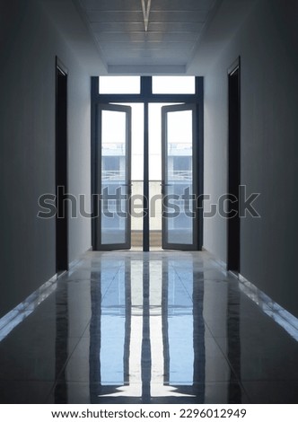 long corridor in office or house with glasses window frame and tiled floor. Corridor and reflection of light with floor at public center. walkway with the doors at the end in an apartment