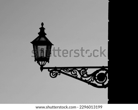 Lamp on wall against sky in black and white 