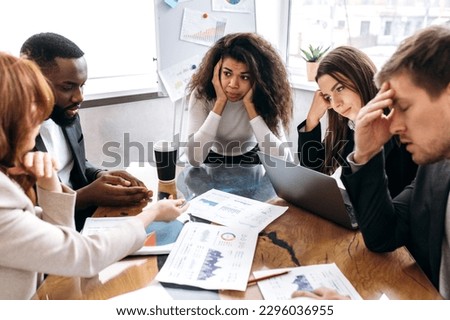 Tired business team are having a briefing meeting, can't find ideas for project. Exhausted male and female employees fail a startup, upset about work troubles, unsuccess and overwork concept Royalty-Free Stock Photo #2296036955