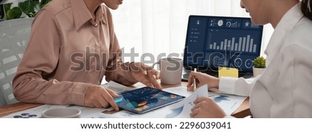 Analyst team colleague discuss financial data on digital dashboard, analyzing charts graph display on laptop and tablet screen. Modern office use business intelligence to plan marketing. Enthusiastic Royalty-Free Stock Photo #2296039041