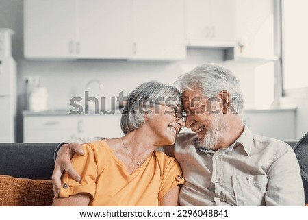 Happy laughing older married couple talking, laughing, standing in home interior together, hugging with love, enjoying close relationships, trust, support, care, feeling joy, tenderness Royalty-Free Stock Photo #2296048841