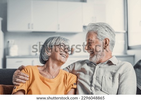 Happy mature husband and wife sit rest on couch at home hugging and cuddling, show care affection, smiling senior loving couple relax on sofa have fun, enjoy tender romantic family weekend together Royalty-Free Stock Photo #2296048865
