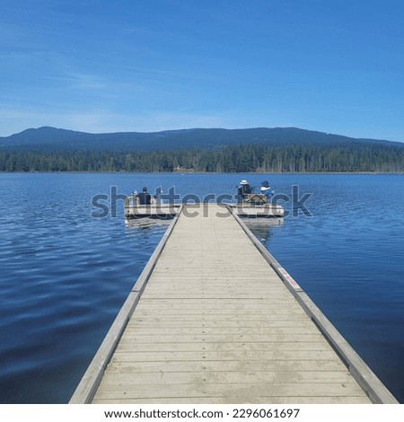 The picture shows a serene navy blue lake with a clear blue sky and fluffy clouds, creating a calming and beautiful scene.
