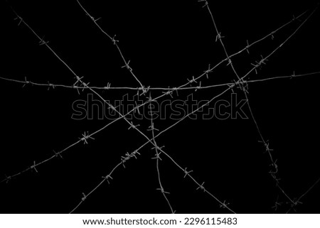 Old security barbed wire isolated on black background. Sharp military security fence. Closeup image. crossed Lines of barbed wire on black background. concentration camp Royalty-Free Stock Photo #2296115483