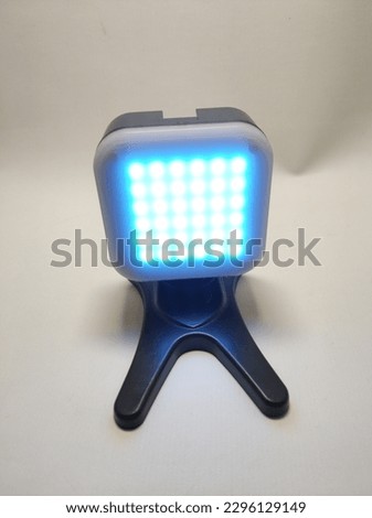 Selective Focus for additional led light to enhance photo and video lighting, black in metal, with a white cover that can be opened and various color filters inserted, white background