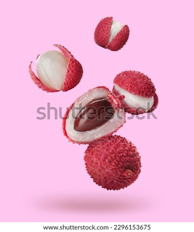 Many fresh lychees falling on pink background Royalty-Free Stock Photo #2296153675
