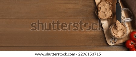 Jar with delicious pate and slices of bread served on wooden table, flat lay. Banner design with space for text