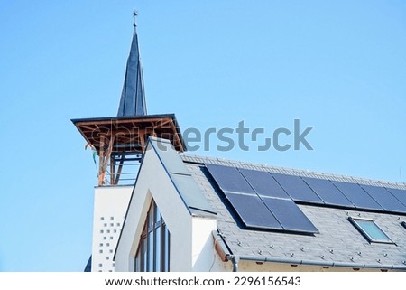 Modern reformed church with solar panels on the roof in Taksony, Hungary, blue sky background.                            