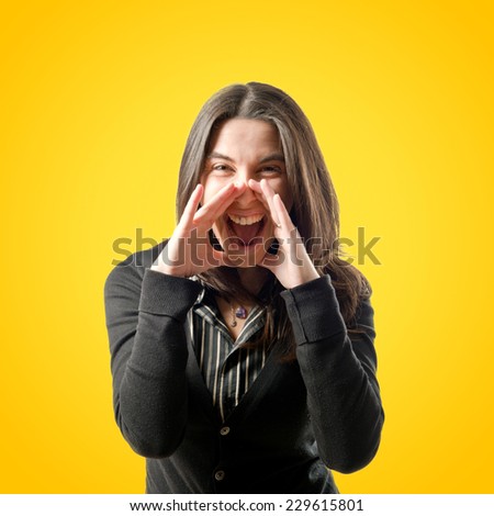 Adult girl shouting over yellow background 
