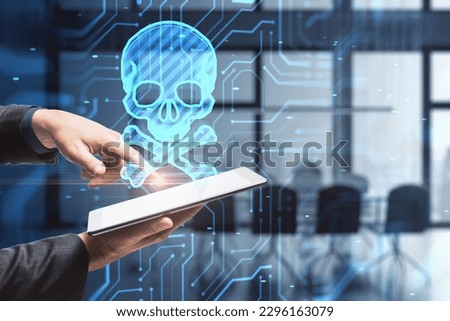 Close up of male hands using pad with glowing skull hologram on blurry office interior background. Hacker system or cyber attack concept. Double exposure