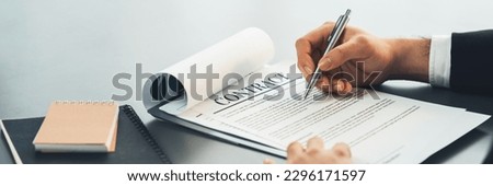 Businessman signs contract agreement paper or business legal form with trust and professionalism. Closeup of hand holding pen in corporate meeting for official business deal. Equilibrium