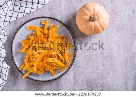 Appetizing vegetarian dessert pumpkin chips on a plate on the table top view