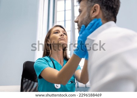 Endocrinologist examining throat of man in clinic. Men with thyroid gland test . Endocrinology, hormones and treatment. Inflammation of the sore throat Royalty-Free Stock Photo #2296188469