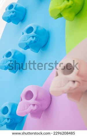 angled view of a row of colorful skulls blue, purple and green on a colored background