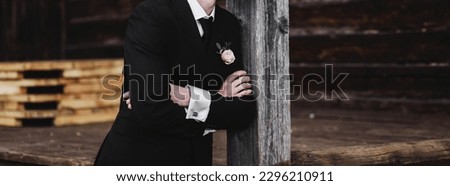 Elegant groom in a jacket poses outdoors. preparing for the wedding Royalty-Free Stock Photo #2296210911
