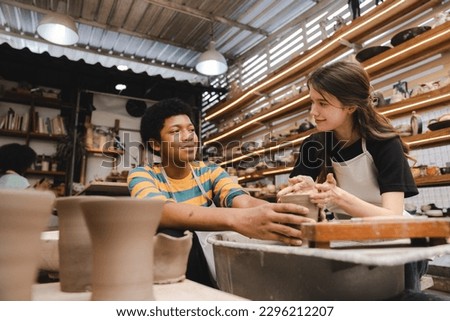 An Afro-haired potter sculpts a ceramic pot from clay on a potter's wheel. Art workshop concept, hands with clay making of a ceramic pot on the pottery wheel, hobby and leisure concept