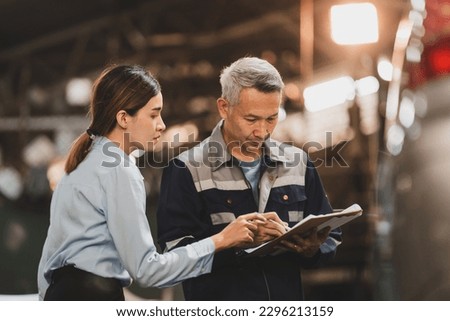 Asian woman customer talking with professional mechanic worker or workshop owner, client checking a maintenance job with garage automobile technician, business of car repair transportation service Royalty-Free Stock Photo #2296213159