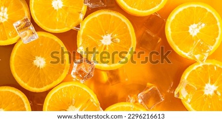 Orange slices and ice cubes with sparkling juice, fresh fruit lemonade with sparkling water and ice cubes, summer lemonade orange drink. Flat lay, top view Royalty-Free Stock Photo #2296216613
