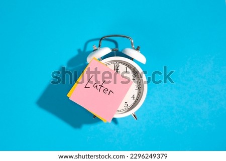 White alarm clock and sticker with the inscription Late on a blue background.