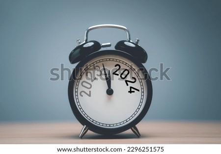 2023 and 2024 on black alarm clock on wooden table with copy space  for preparation of Merry Christmas and Happy new year concept. Royalty-Free Stock Photo #2296251575