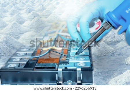 Rechargeable sodium-ion battery and salt farm for lithium-ion alternative concept. Sustainable energy. Battery technology. Technician use soldering iron to solder metal and wire of sodium-ion battery. Royalty-Free Stock Photo #2296256913